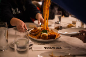 woman eating homemade meatballs and pasta at vini di casa on food tour of providence